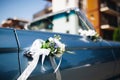 Closeup of a vintage blue car adorned with white flowers on a sunny day Royalty Free Stock Photo