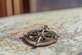 Closeup of vintage compass on old world map in front of heavy cu Royalty Free Stock Photo