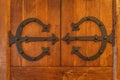 Closeup on vintage, old wooden door with cast iron ornate hinges Royalty Free Stock Photo