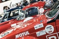 Closeup of a vintage racecar with red and blue racecars in the background