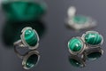 Closeup vintage silver earrings and ring with malachite on background of silver pendant and piece of malachite on black table Royalty Free Stock Photo