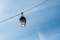 Vintage street lamp on cable on blue sky background