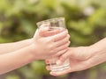 Closeup vintage woman hand giving glass of fresh water to child Royalty Free Stock Photo