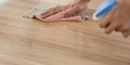 Closeup waiter`s hand use a liquid cleaner and a towel to wipe off the stains on the table