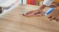 Closeup waiter`s hand use a liquid cleaner and a towel to wipe off the stains on the table