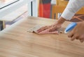 Closeup waiter`s hand use a liquid cleaner and a towel to wipe off the stains on the table