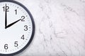Closeup of wall clock show two o`clock on white marble background Royalty Free Stock Photo