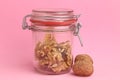 Closeup of walnut kernels inside a jar with two whole walnuts on the side of the jar Royalty Free Stock Photo