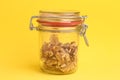 Closeup of walnut kernels inside a jar on a yellow background Royalty Free Stock Photo