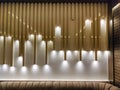 The warm lights in the dark in a striped white wall as decoration and illumination