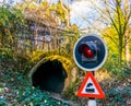 Closeup of a warning traffic light, railroad tunnel with warning sign Royalty Free Stock Photo