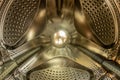 Closeup of washing machine metal drum with dot holes in gold plated color. Industrial design pattern. Used household utility with Royalty Free Stock Photo