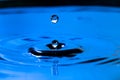 Closeup water drop falling and dripping from the top to the surface of water that makes two water drops. Water drop splash and Royalty Free Stock Photo