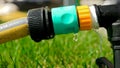 Closeup of water droplets dripping from leaking garden hose pipe. Water waste, gardening equipment Royalty Free Stock Photo