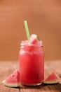 Closeup watermelon juice in glass on wood table with with slices