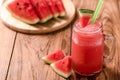 Closeup watermelon juice in glass on wood table with with slices