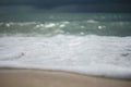 Closeup wave of the sea with blur rainy cloud in background