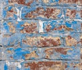 weathered brick wall with peeling blue and white paint Royalty Free Stock Photo