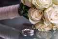 Closeup of a wedding bouquet next to wedding rings on glass Royalty Free Stock Photo