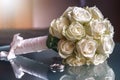 Closeup of a wedding bouquet next to wedding rings on glass Royalty Free Stock Photo