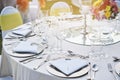 Closeup of wedding reception dinner table setting with water glasses, napkin, plate, spoon and fork
