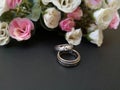 Closeup with wedding rings and beautiful roses flower background. Royalty Free Stock Photo