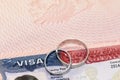 Closeup of wedding rings on usa visa as concept of marriage of convenience