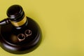 Closeup of wedding rings on wooden mallet at table in courtroom Royalty Free Stock Photo