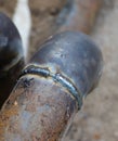 Closeup of a welded butt joint with some defects. Two metal pipes welded together