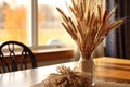 closeup of a wheat bundle centerpiece on a dining table