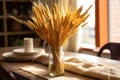 closeup of a wheat bundle centerpiece on a dining table