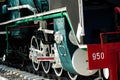 Closeup wheel of train. Green red and white train. Antique vintage train locomotive. Old steam engine locomotive. Black locomotive