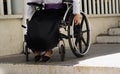 Closeup wheels of wheelchair with woman sitting in it, physical handicapped concept