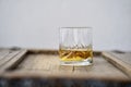 Closeup of a whisky glass with golden shimmering whisky on a shabby wooden rustic table Royalty Free Stock Photo