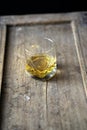 Closeup of a whisky glass on a shabby rustic wooden furniture Royalty Free Stock Photo