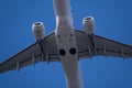 Closeup of white airplane fuselage with two turbojet engines against bright blue sky