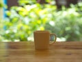 Closeup White Cofee Cup on the wooden table with a green leaf bokeh. Royalty Free Stock Photo