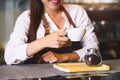 Closeup of white coffee cup with beautiful Asian woman barista background for serving to customer. Job and occupation. Food and Royalty Free Stock Photo