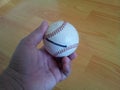 Closeup and of a white cricket hard ball in hand Royalty Free Stock Photo