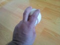 Closeup and of a white cricket hard ball in hands Royalty Free Stock Photo