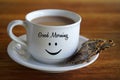 Closeup of white cup of morning coffee with Good morning greeting and a smile emoticon on it and healthy seed crackers on a plate Royalty Free Stock Photo