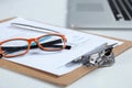 Closeup of white desktop with laptop, glasses, coffee cup, notepads and other items on blurry city background Royalty Free Stock Photo