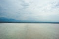 Closeup white empty floor with panorama view of horizontal line of mountain view with cloudy sky