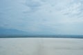 Closeup white empty floor with panorama view of horizontal line of mountain view with cloudy sky