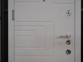 Closeup of white entrance modern armored front door with few locks and handle