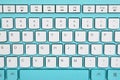 Closeup of white keyboard keys on a turquoise background