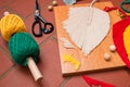 Closeup of macrame leaf in the process of shaping and different craft supplies.