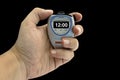 Closeup of a white man's hand holding an electronic timer on an isolated black background Royalty Free Stock Photo