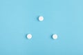 Closeup of white pills on a blue background. Heap of pills - medical background