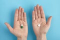 Closeup of white pills on a hands on a blue background. Heap of pills - medical background. Close up